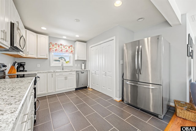 227 Outrigger Dr Lot 132, Kill Devil Hills, NC 27948 - kitchen featuring light stone countertops, recessed lighting, stainless steel appliances, white cabinets, and a sink
