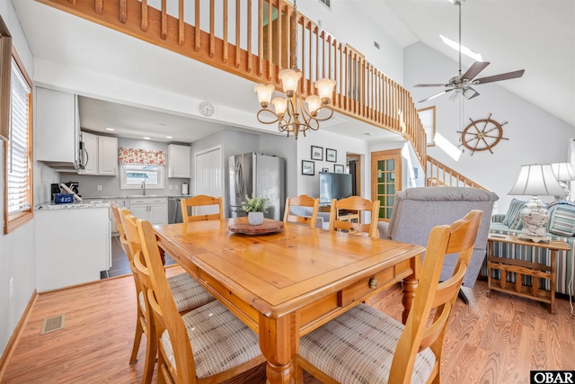 227 Outrigger Dr Lot 132, Kill Devil Hills, NC 27948 - dining space with ceiling fan with notable chandelier, high vaulted ceiling, visible vents, and light wood-type flooring
