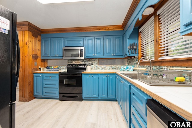 718 Canal Dr Lot 308, Kill Devil Hills, NC 27948 - kitchen with black appliances, blue cabinets, decorative backsplash, light countertops, and light wood finished floors