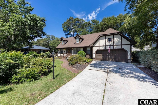 718 Canal Dr Lot 308, Kill Devil Hills, NC 27948 - english style home with an attached garage, stucco siding, concrete driveway, covered porch, and a shingled roof