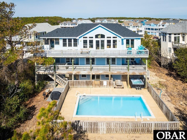 back of house featuring a balcony, a patio area, a fenced in pool, and a fenced backyard