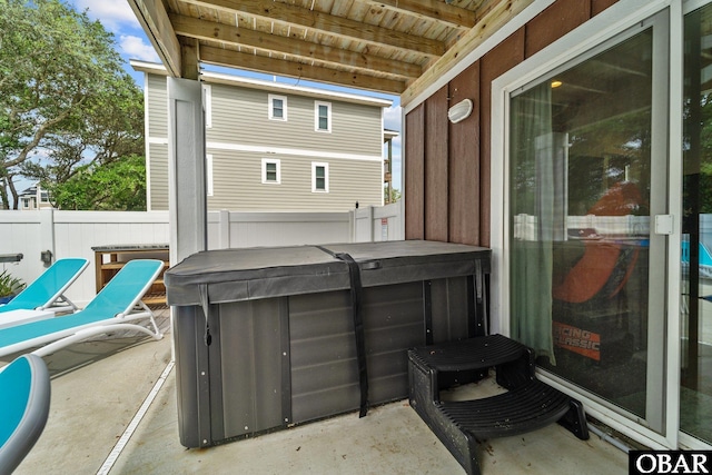 view of patio / terrace featuring a hot tub and fence
