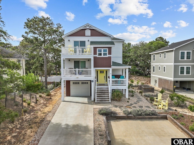 raised beach house featuring stairs, a balcony, a garage, concrete driveway, and a porch