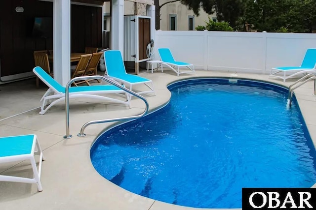 view of pool with a patio area and fence