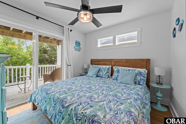 bedroom with access to outside, multiple windows, wood finished floors, and ceiling fan