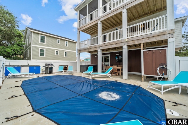 view of swimming pool with grilling area, a fenced backyard, and a patio