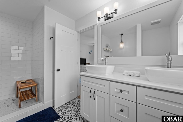 full bath featuring double vanity and a tile shower