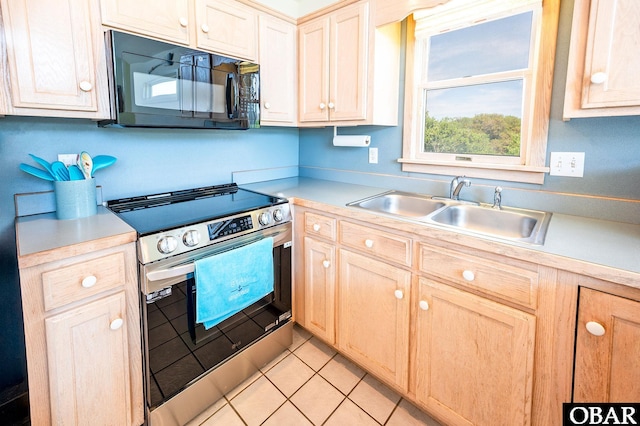 kitchen with black microwave, a sink, light countertops, light tile patterned floors, and stainless steel electric stove