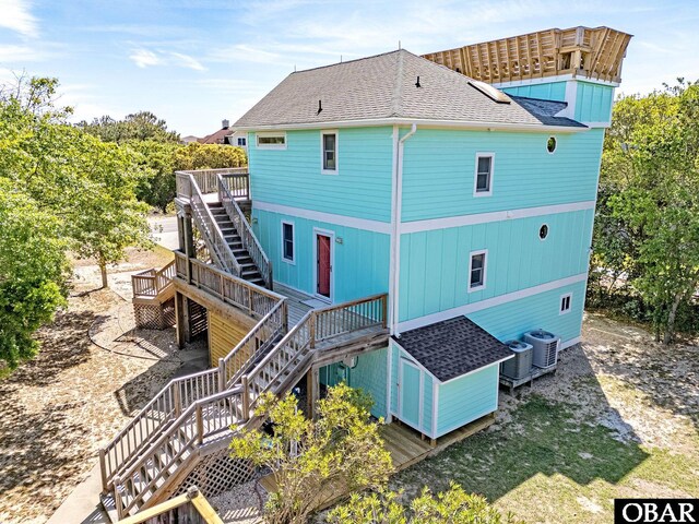 rear view of property featuring a wooden deck, stairs, central AC unit, and roof with shingles