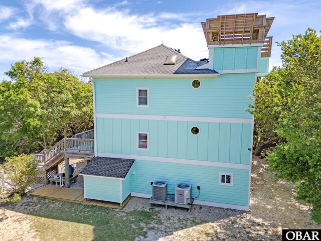 back of house with central AC, a shingled roof, a wooden deck, and stairway
