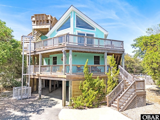 view of front of property with concrete driveway, a deck, stairway, and a carport