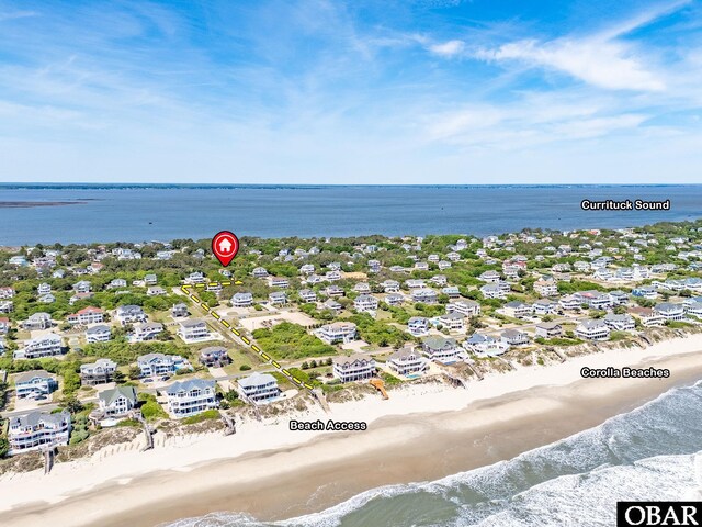 drone / aerial view featuring a residential view, a beach view, and a water view