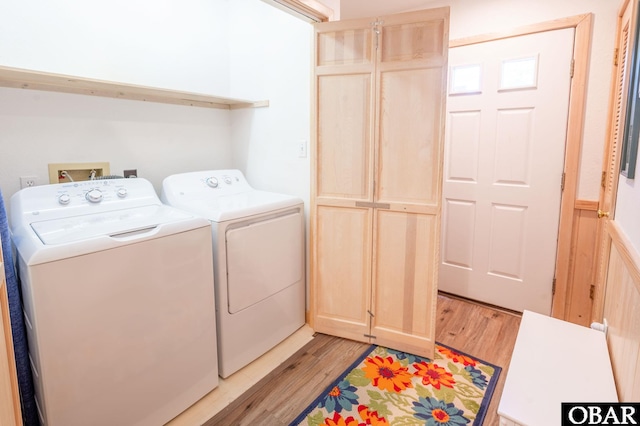 laundry area with washing machine and clothes dryer, laundry area, and light wood-style flooring