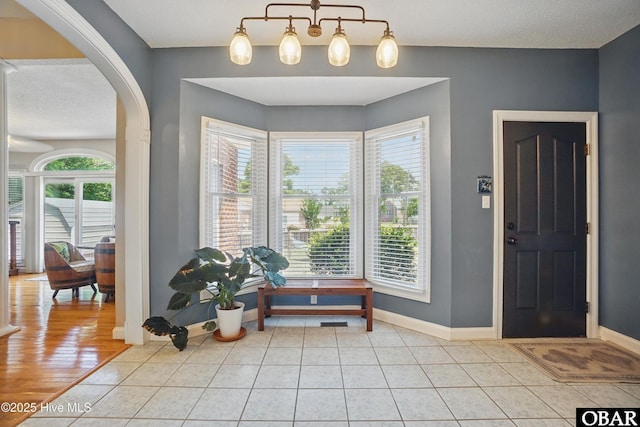 107 Magnolia Dr Lot 75, 76, 77, Camden, NC 27921 - entrance foyer with arched walkways, baseboards, and light tile patterned flooring