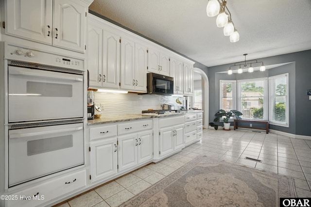107 Magnolia Dr Lot 75, 76, 77, Camden, NC 27921 - kitchen featuring double oven, black microwave, gas stovetop, backsplash, and light tile patterned floors