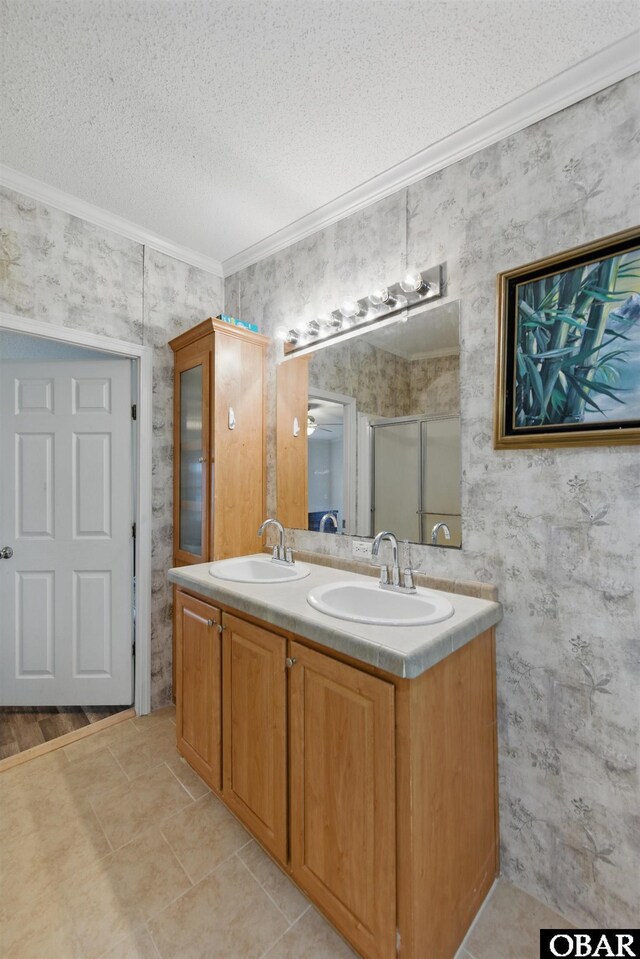 138 Swains Ln Lot 3, Barco, NC 27917 - bathroom with crown molding, wallpapered walls, a textured ceiling, double vanity, and a shower with shower door