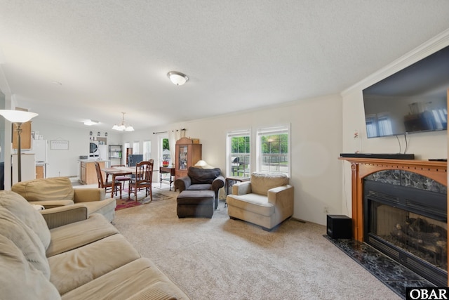 138 Swains Ln Lot 3, Barco, NC 27917 - living room featuring carpet floors, a fireplace, a chandelier, crown molding, and a textured ceiling