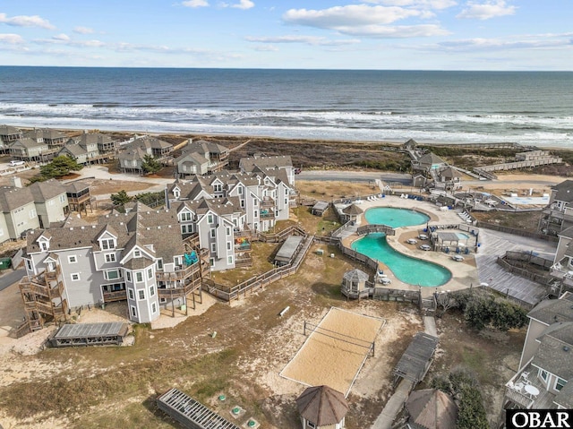 drone / aerial view featuring a view of the beach, a water view, and a residential view