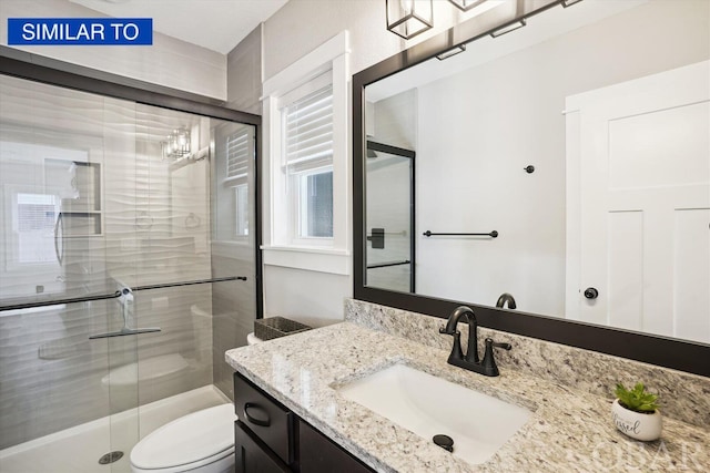 full bath featuring a stall shower, vanity, and toilet