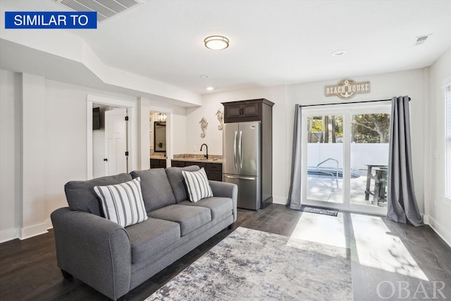 living area with dark wood-type flooring, recessed lighting, visible vents, and baseboards