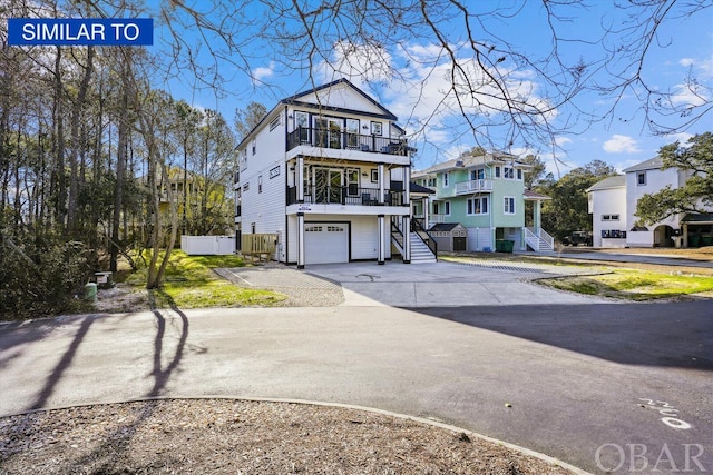 coastal inspired home featuring an attached garage, a residential view, stairway, and concrete driveway