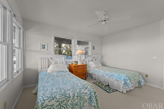 carpeted bedroom with multiple windows, a ceiling fan, and baseboards