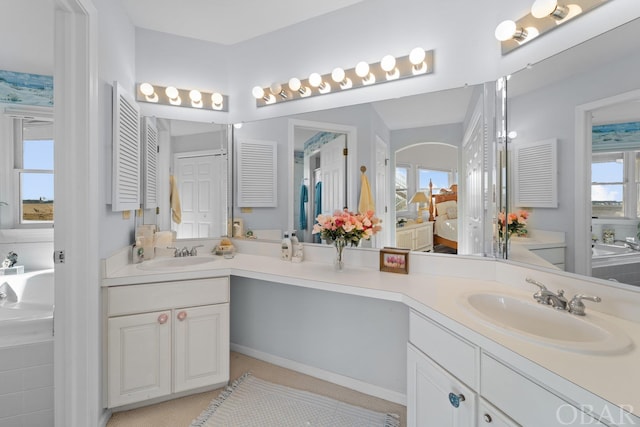 bathroom with a closet, ensuite bath, and vanity