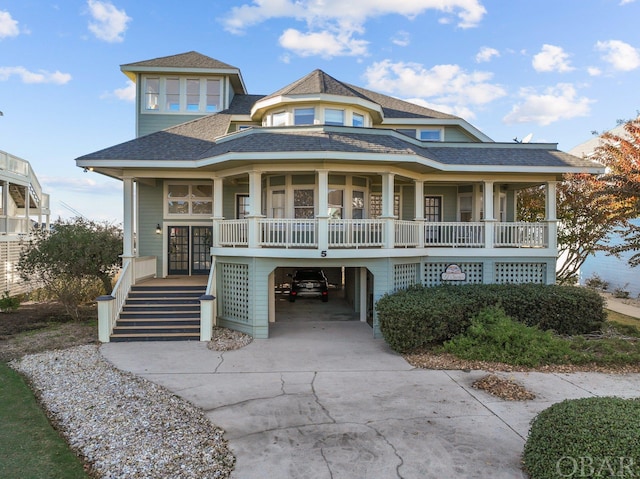 view of front of house with a porch, a shingled roof, stairs, driveway, and a carport