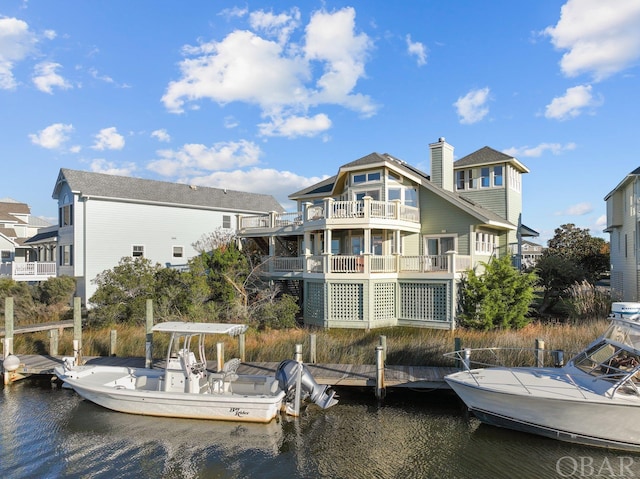 rear view of property with a chimney and a water view