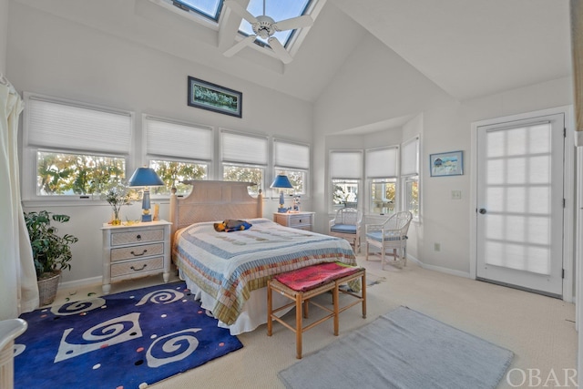 bedroom with a skylight, baseboards, multiple windows, and high vaulted ceiling