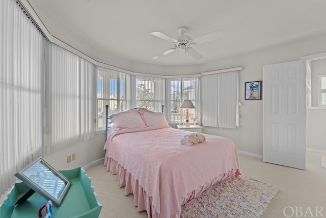 bedroom featuring light carpet, ceiling fan, and baseboards