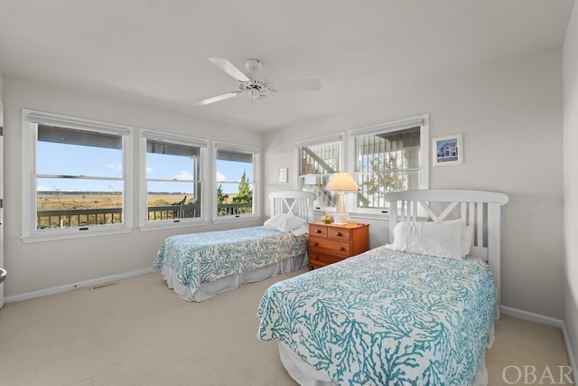 carpeted bedroom with a ceiling fan, multiple windows, visible vents, and baseboards