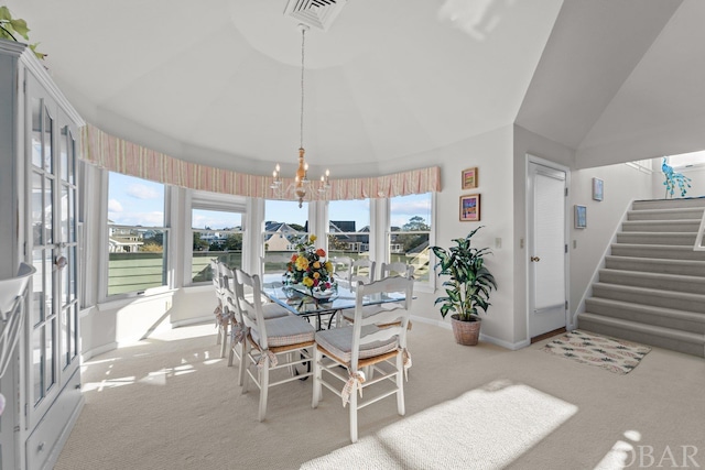 carpeted dining space featuring visible vents, stairway, an inviting chandelier, vaulted ceiling, and baseboards