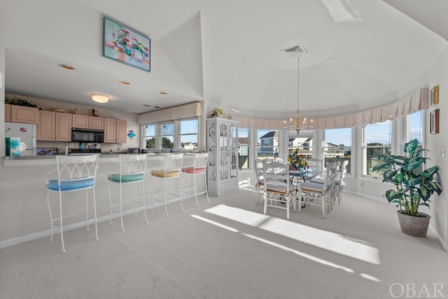 dining room featuring light carpet, plenty of natural light, a chandelier, and visible vents