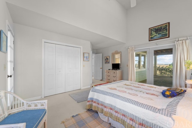 bedroom featuring access to exterior, a high ceiling, baseboards, and carpet flooring