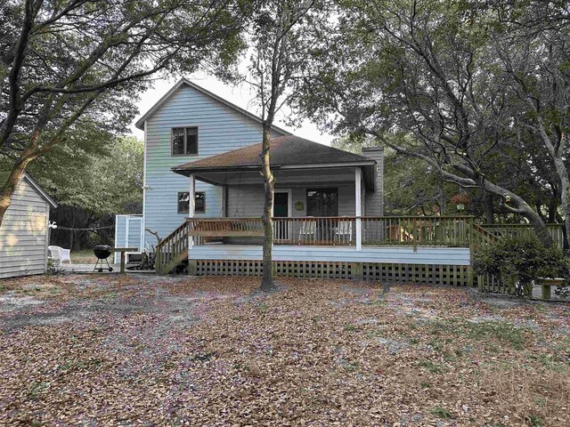 view of front of home with a chimney and a deck