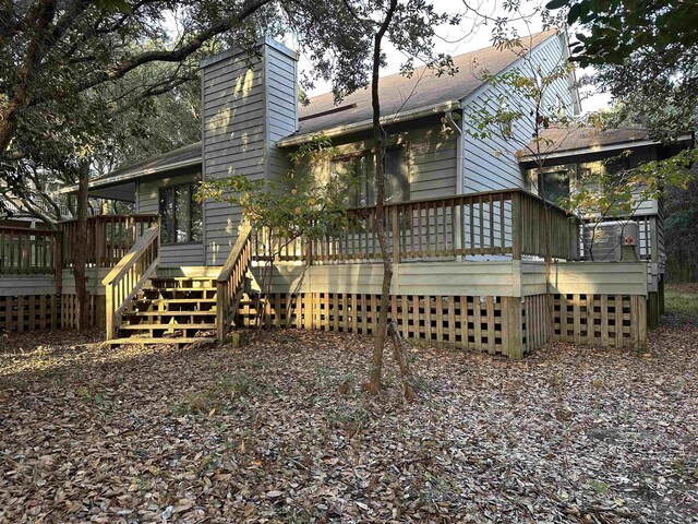 back of house featuring a wooden deck and a chimney