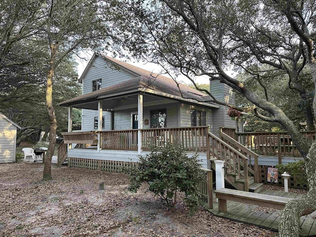 view of front facade with a chimney, stairway, and a deck