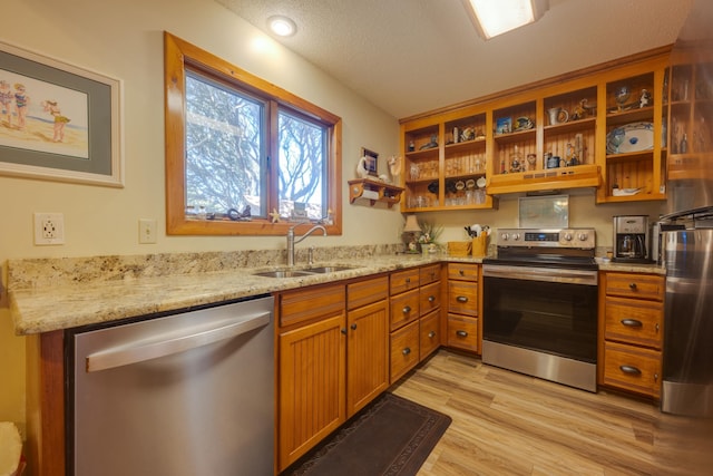 kitchen featuring stainless steel appliances, a sink, under cabinet range hood, and open shelves