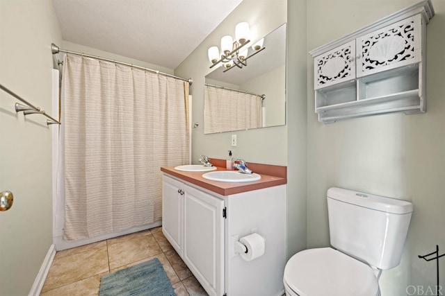 full bath featuring double vanity, a sink, toilet, and tile patterned floors