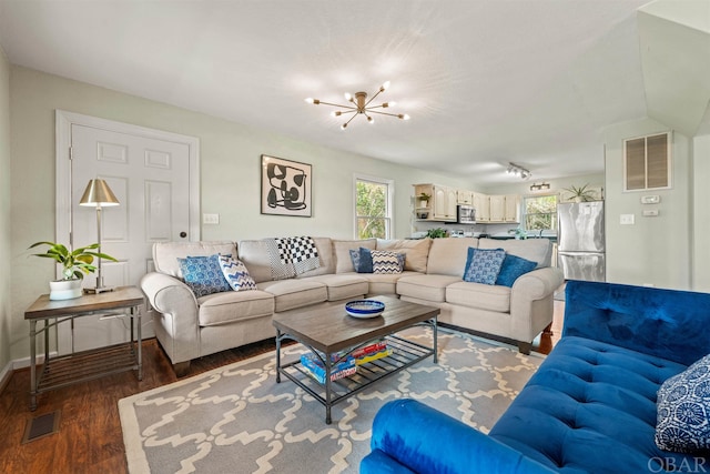 living area featuring dark wood-type flooring, plenty of natural light, and visible vents