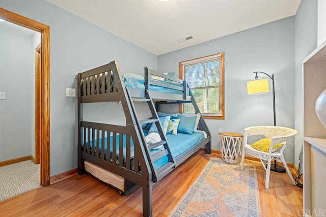 bedroom featuring visible vents, baseboards, and wood finished floors