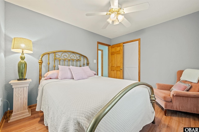 bedroom featuring light wood-style flooring, baseboards, and ceiling fan