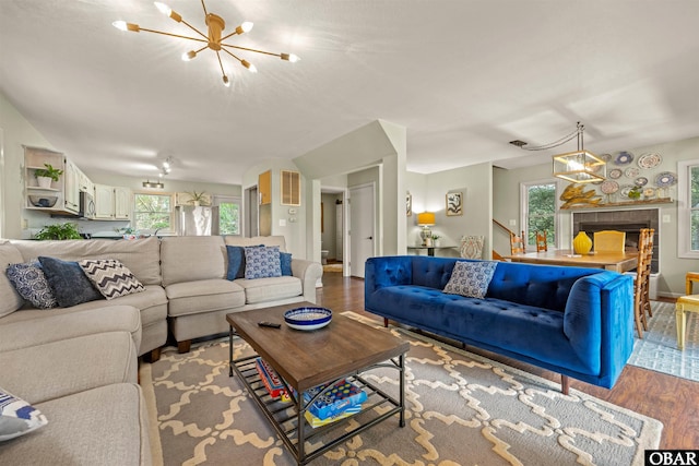 living room featuring a chandelier, light wood-style flooring, and stairs