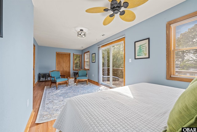 bedroom featuring access to outside, baseboards, and light wood-style flooring