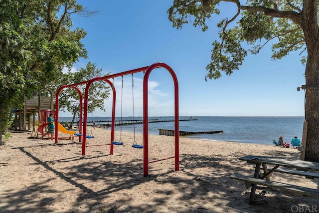 communal playground featuring a view of the beach and a water view