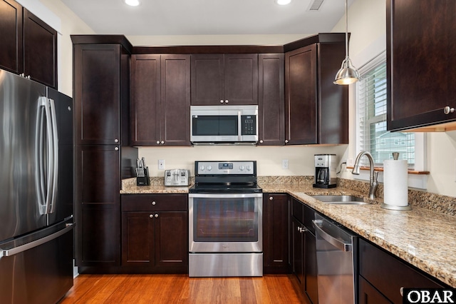 655 Pampas Ct Lot 162, Corolla, NC 27927 - kitchen featuring stainless steel appliances, light wood-style floors, light stone counters, dark brown cabinetry, and recessed lighting