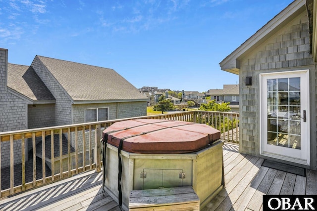 wooden deck with a hot tub and a residential view