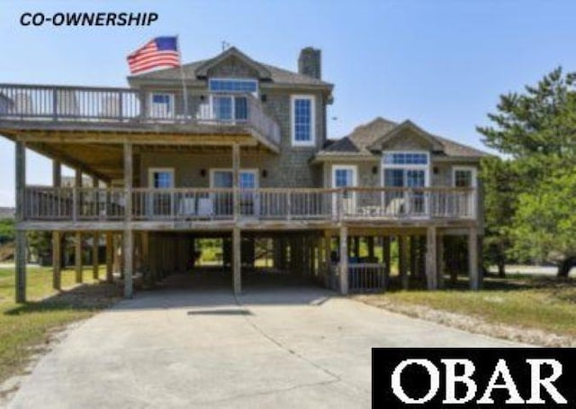 raised beach house featuring driveway and a carport