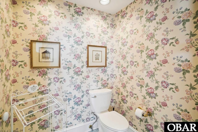 half bathroom featuring toilet and wallpapered walls